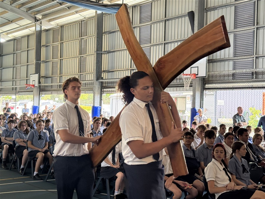 student senior leaders carrying a wooden cross
