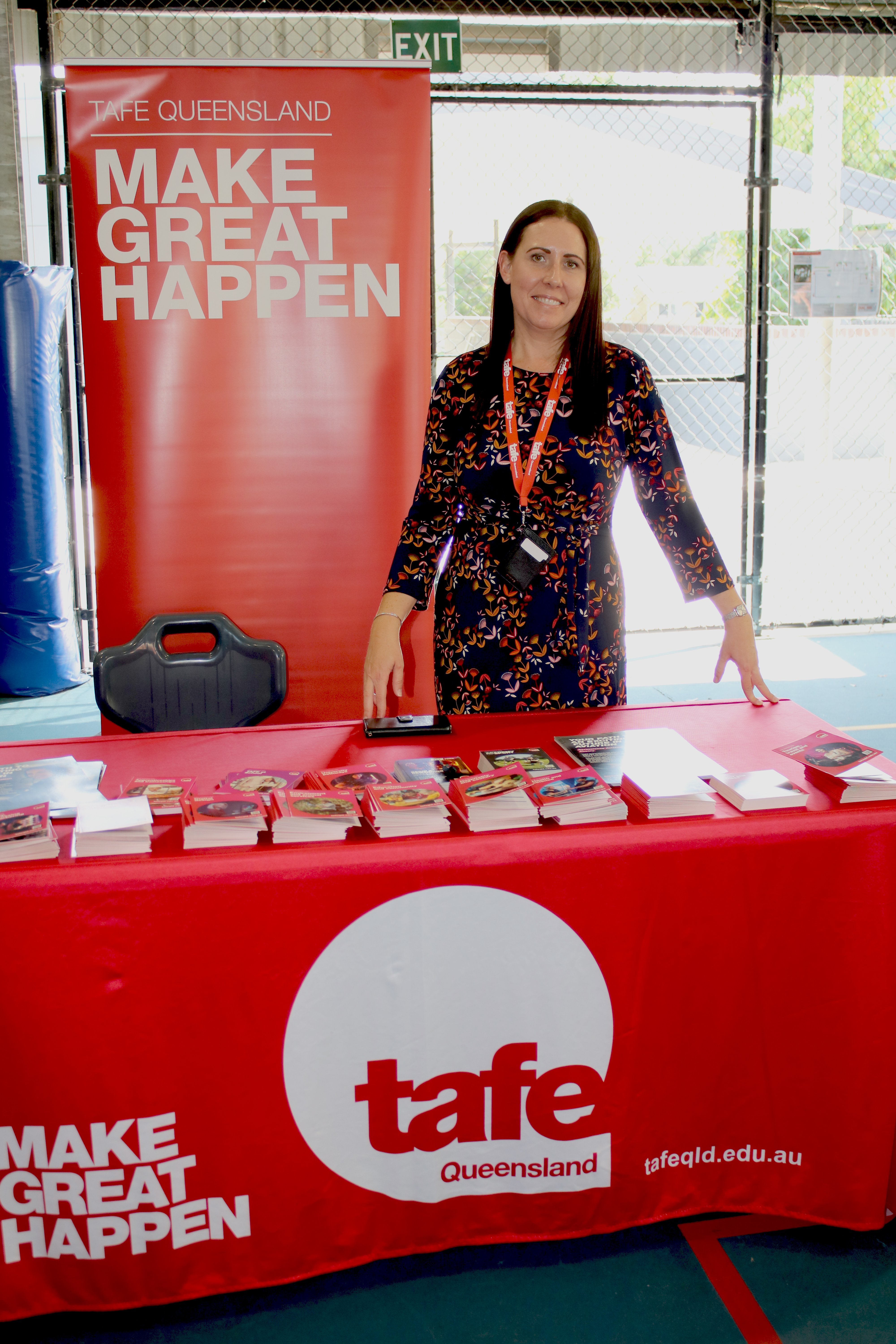 A lady standing at TAFE marketing flyers